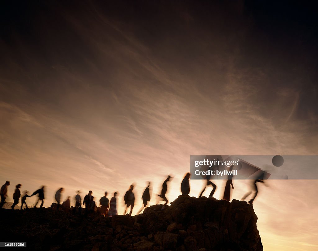 Blurred line of people on the edge of a cliff