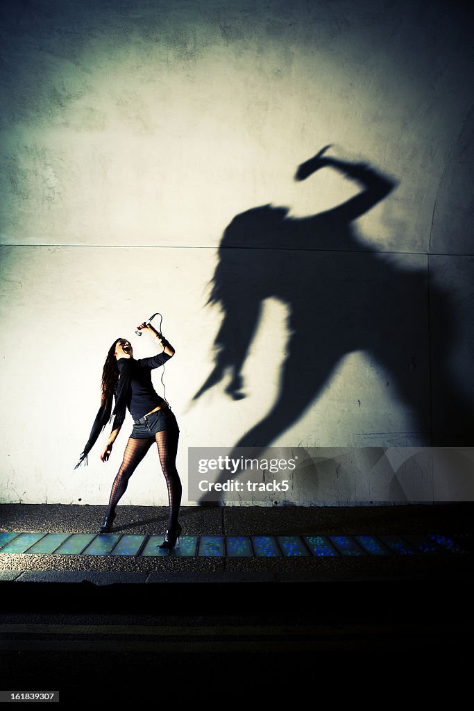 Classic rock pose and shadow from a confident young woman