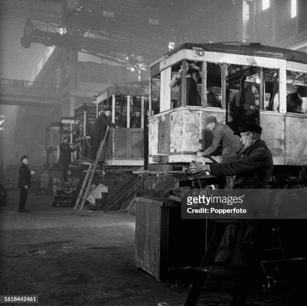 Employees repair and restore tram cars in one of the two reconstructed halls of the AEG turbine factory in Berlin in Allied-occupied Germany in...