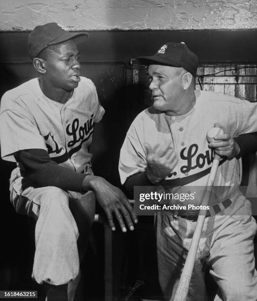 Satchel Paige , Right Handed Pitcher for the St Louis Browns talks with team coach Rogers Hornsby in the dugout before the Major League Baseball...