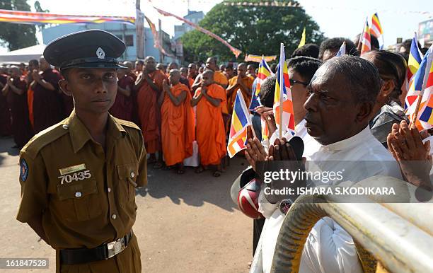 Sri Lankan policeman keeps watch during a rally calling for a ban on Islamic halal-slaughtered meat at Maharagama, a suburb of the capital Colombo,...