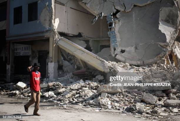 Man walks in Port-au-Prince February 2, 2010. Looters and scavengers have moved into the downtown commercial district, taking what they can from the...