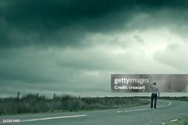 man looking out on dark country road - crossing the road stock pictures, royalty-free photos & images