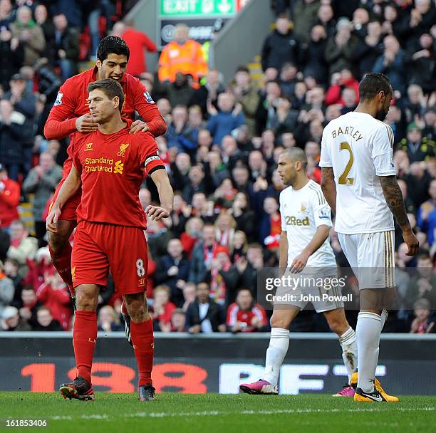 Luis Suarez of Liverpool jumps onto the shoulders of Steven Gerrard after Gerrard scored from the penalty spot, during the Barclays Premier League...