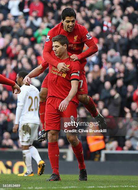 Steven Gerrard of Liverpool celebrates with Luis Suarez after scoring the first goal from the penalty spot during the Barclays Premier League match...