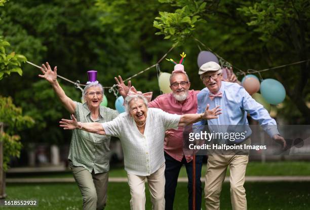 senior friends celebrating birthday together. - happy birthday flowers images stock pictures, royalty-free photos & images