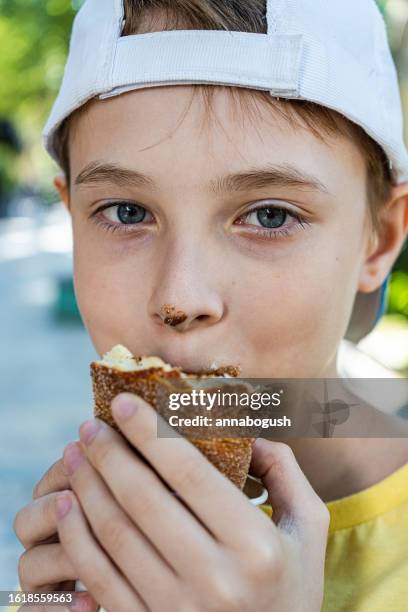 portrait of a boy with chocolate on his nose eating an ice cream trdelnik - trdelník stock pictures, royalty-free photos & images