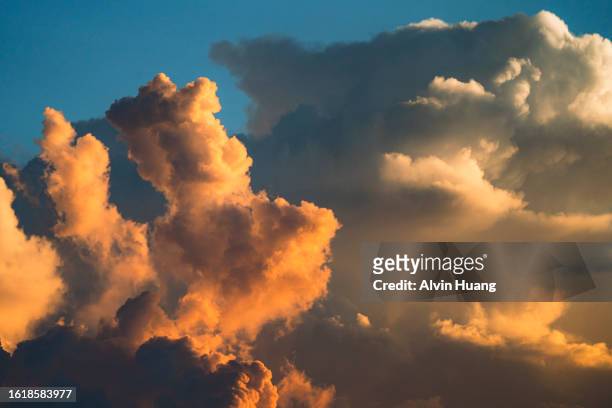 in the summer, the cinematic cumulus clouds fill the sky, displaying a variety of colors and transformations during the sunset hours. - cinematic stock pictures, royalty-free photos & images