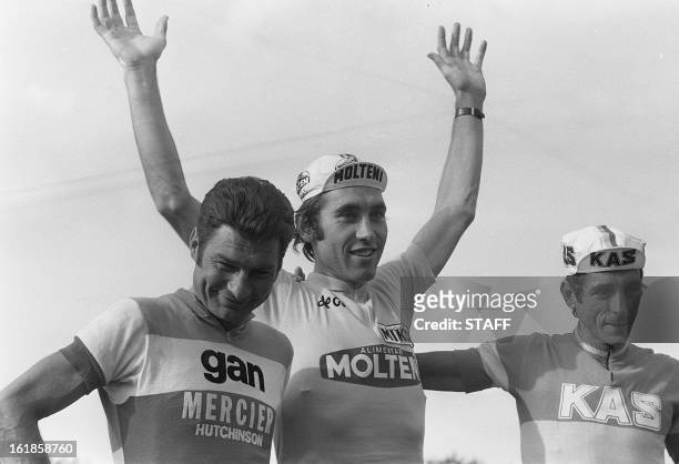 Belgian Eddy Merckx smiles on the podium as he waves to the crowd 21 July 1974 in Paris after winning his fifth Tour de France in front of Raymond...