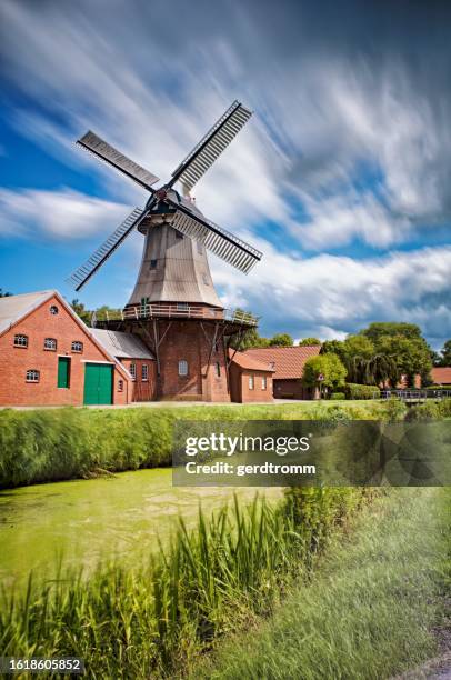 windmill by a canal in summer, warsingsfehn, east frisia, lower saxony, germany - ostfriesland stock-fotos und bilder