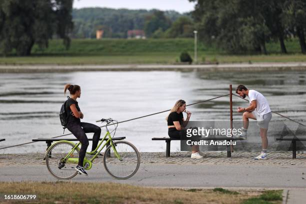Woman rides a bicycle as daily life continues in the 4th biggest city of Croatia, Osijek on August 16, 2023.