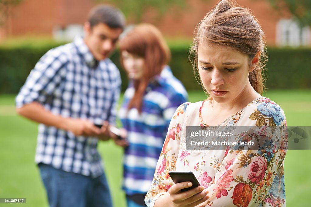 A concerned teenage girl being bullied by text message