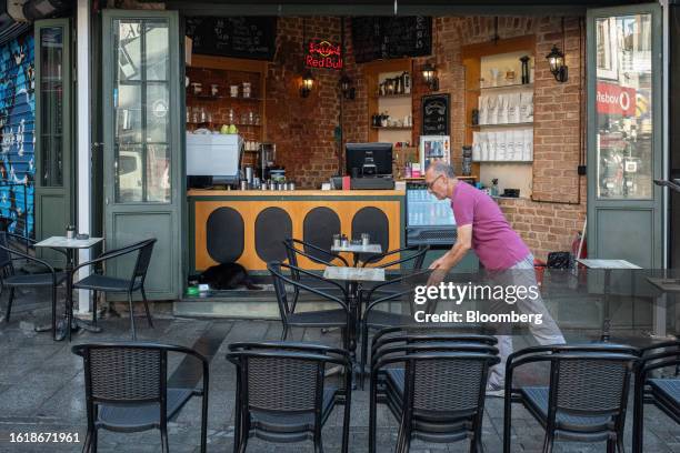 Worker organizes tables outside a cafe ahead of the day's trading in Istanbul, Turkey, on Tuesday, Aug. 22, 2023. The Turkish central bank announces...