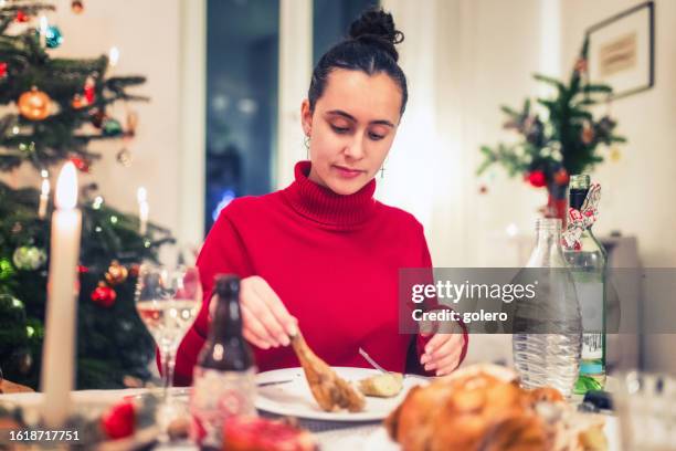 young woman eating poultry at christmas table - celebrity roast stock pictures, royalty-free photos & images
