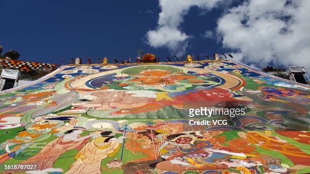 Huge Thangka painting is displayed on hillsides during a traditional "sunning the Buddha" ceremony at the Drepung Monastery on August 16, 2023 in...