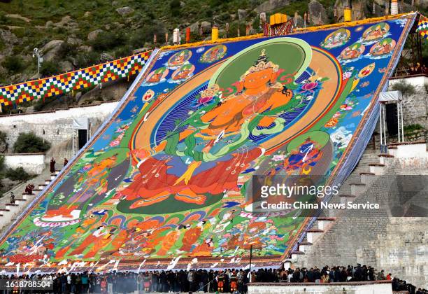 Huge Thangka painting is displayed on hillsides during a traditional "sunning the Buddha" ceremony at the Drepung Monastery on August 16, 2023 in...