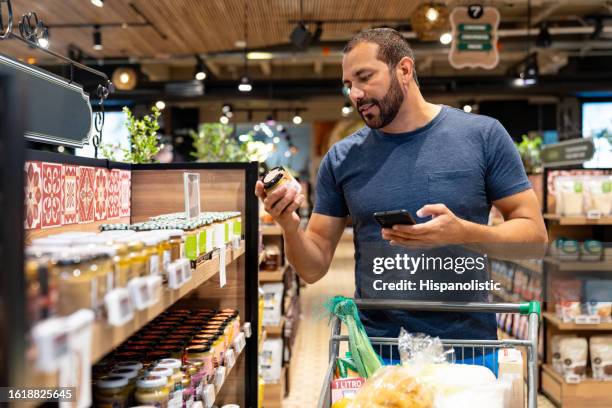 healthy eating man shopping for organic products at the supermarket - sports merchandise stock pictures, royalty-free photos & images