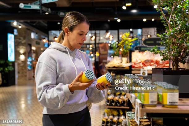 healthy eating woman shopping at the supermarket and reading the label on a product - expiry date stock pictures, royalty-free photos & images