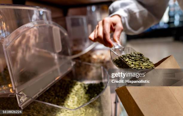 nahaufnahme einer frau, die getreide in einem bio-supermarkt kauft - supermarkt gang stock-fotos und bilder