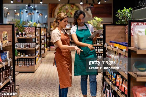 business manager training a new retail clerk at a supermarket - convenience store stock pictures, royalty-free photos & images