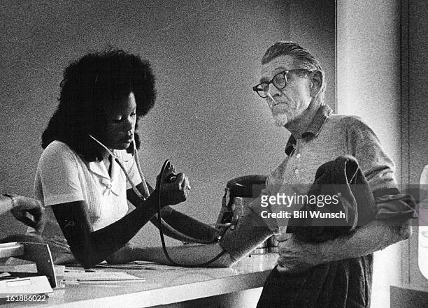 Technician Mary Simmons of Plasma Components, Inc., tests the blood pressure of Eugene Walters before determining whether to buy blood.;