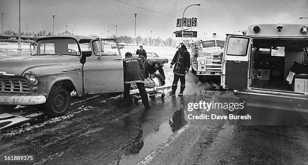 Ambulance attendants assist Paul Lc/erne Green of 500 W. 44th Ave., after hªwas injured Wednesday when the pickup truck (was driving collided with an...