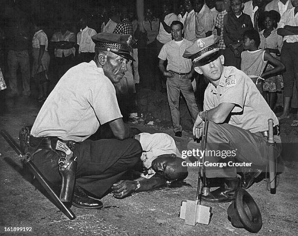 Shooting Victim Edward P. Rowe Of 811 30th St., Lies Wounded; Denver Reserve Police officers George O'Neal, left, and C. B.Coprich await ambulance.;...
