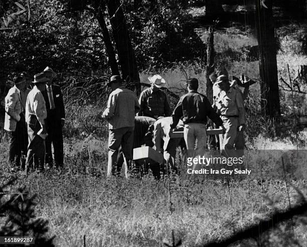 Douglas County officers and FBI men shown clustering around spot in the wooded hills southwest of Sedalia, Colo., where the bones of Adolph Coors III...
