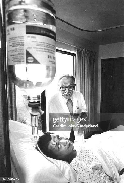 Doc" Ernest Ceriani of Kremmling and his patient, Richard McMahan, check McMahon's IV. A Kremmling physician more than 30 years, Dr. Ceriani...