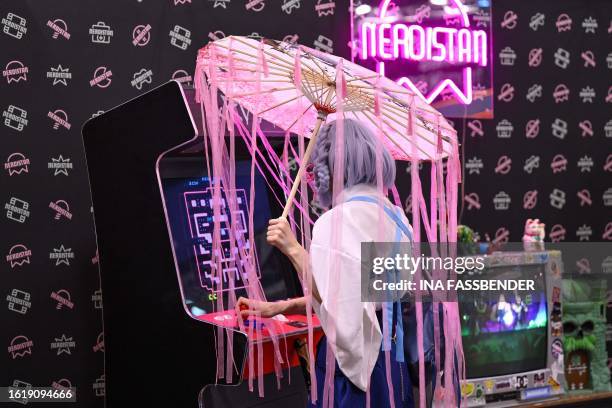 Cosplayer plays a retro game at the Gamescom video game fair in Cologne, western Germany, on August 23, 2023. According to the organisers, around...