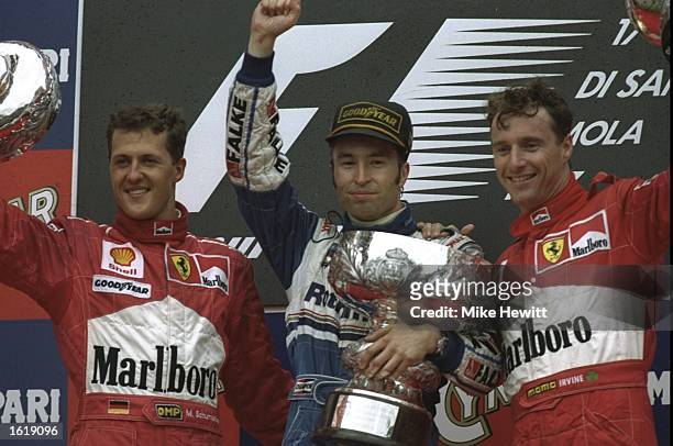 Michael Schumacher of Germany, Heinz-Harald Frentzen of Germany and Eddie Irvine of Ireland celebrate on the podium at the San Marino Grand Prix....