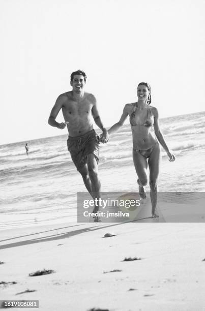 coppia che corre sulla spiaggia - couple running on beach foto e immagini stock