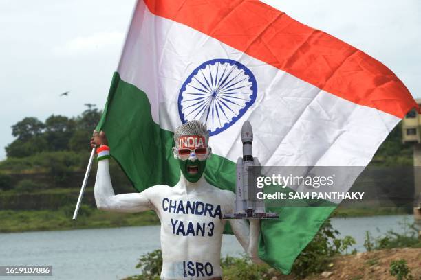 Man holding a national flag celebrates the successful lunar landing of Chandrayaan-3 spacecraft on the south pole of the Moon, in Ahmedabad on August...