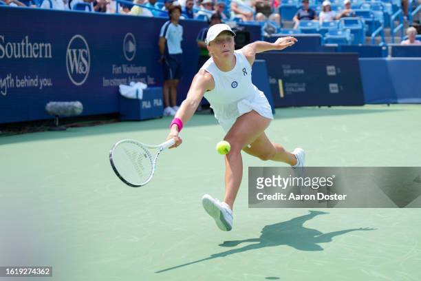 Iga Swiatek of Poland returns a shot to Danielle Collins of the United States during their match at the Western & Southern Open at Lindner Family...