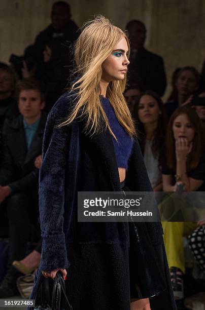 Cara Delevingne walks the catwalk during the Topshop Unique show at the Tate Modern during London Fashion Week Fall/Winter 2013/14 on February 17,...