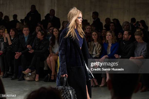 Cara Delevingne walks the catwalk during the Topshop Unique show at the Tate Modern during London Fashion Week Fall/Winter 2013/14 on February 17,...