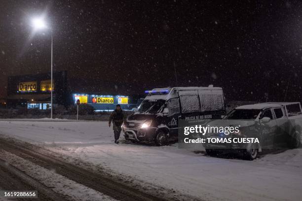 Police officers guard a Diarco supermarket after an attempted looting, in Bariloche, Rio Negro Province, Argentina, on August 23, 2023. Arrests have...