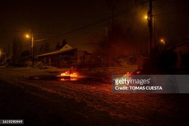 Burning tyres are seen near a Diarco supermarket after an attempted looting, in Bariloche, Rio Negro Province, Argentina, on August 23, 2023. Arrests...