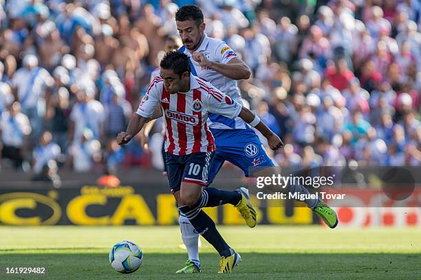 Isaac Romo of Puebla fights for the ball with Marco Fabian of Chivas during a match between Puebla and Chivas as part of the Clausura 2013 at...