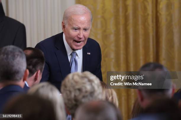 President Joe Biden greets audience members during an event recognizing the first anniversary of the Inflation Reduction Act in the East Room at the...