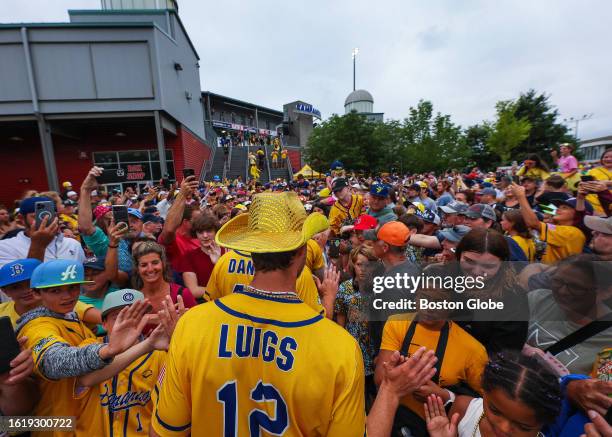 Brockton, MA The Savannah Bananas slap high fives with their fans as they parade outside outside Brockton's Campanelli Stadium on their first ever...