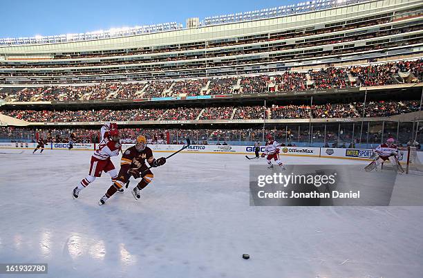 Tom Serratore of the Minnesota Golden Gophers chases the puck with Jefferson Dahl of the Wisconsin Badgers during the Hockey City Classic at Soldier...