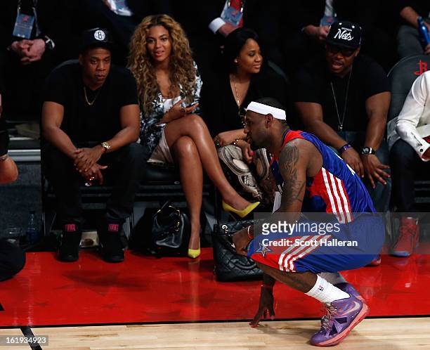 Rapper Jay-Z and Beyonce look over at LeBron James of the Miami Heat and the Eastern Conference during the 2013 NBA All-Star game at the Toyota...