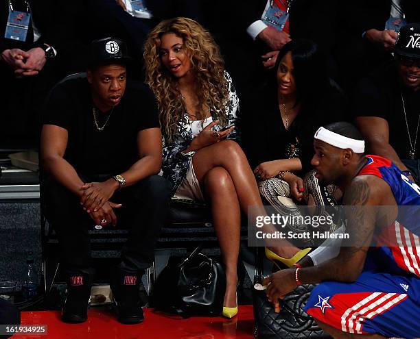 Rapper Jay-Z and Beyonce look over at LeBron James of the Miami Heat and the Eastern Conference during the 2013 NBA All-Star game at the Toyota...