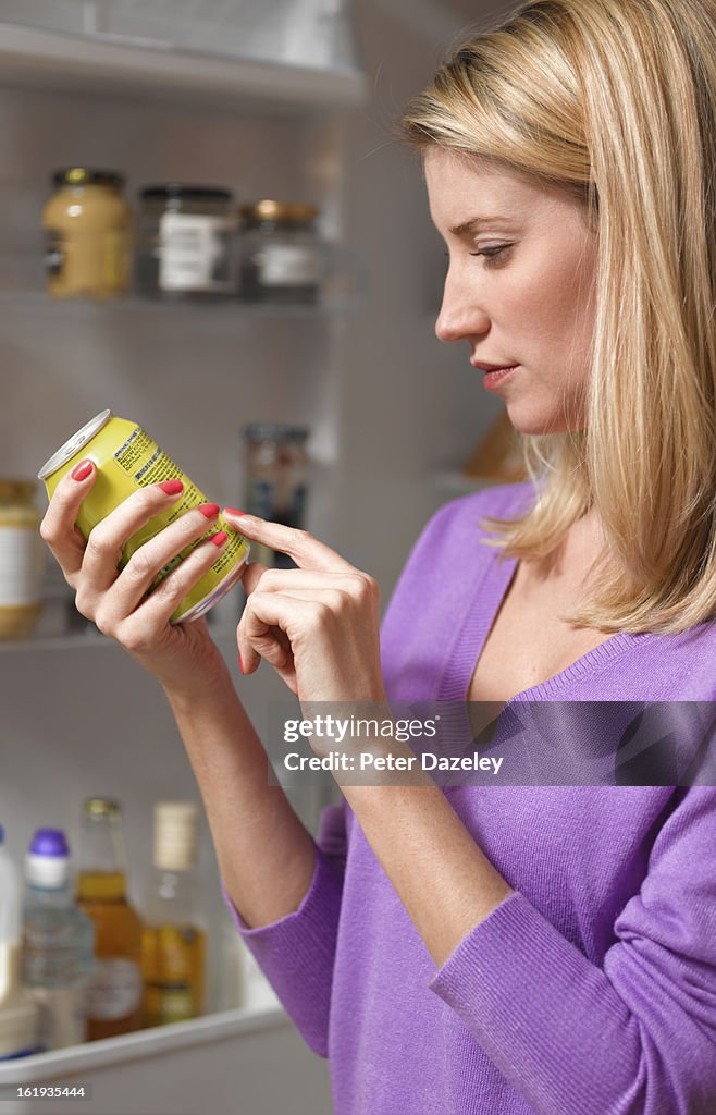 Woman checking ingredients on can