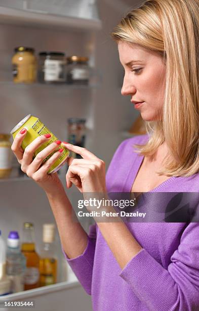 woman checking ingredients on can - food safety kitchen stock pictures, royalty-free photos & images