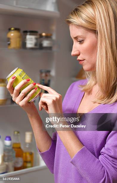 woman checking ingredients on can - junk stock pictures, royalty-free photos & images