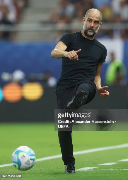 Pep Guardiola, Manager of Manchester City, passes the ball during the UEFA Super Cup 2023 match between Manchester City FC and Sevilla FC at...