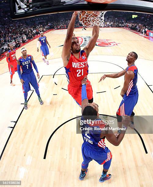 Tim Duncan of the San Antonio Spurs and the Western Conference dunks over Kyrie Irving of the Cleveland Cavaliers and the Eastern Conference during...