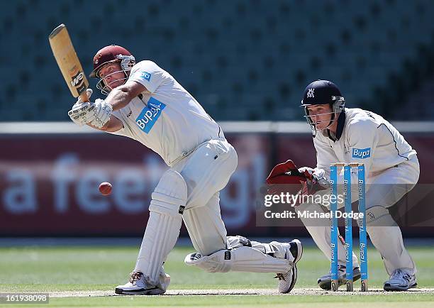 James Hopes of the Queensland Bulls hits the ball in front of Victorian Bushrangers keeper Peter Handscomb during day one of the Sheffield Shield...